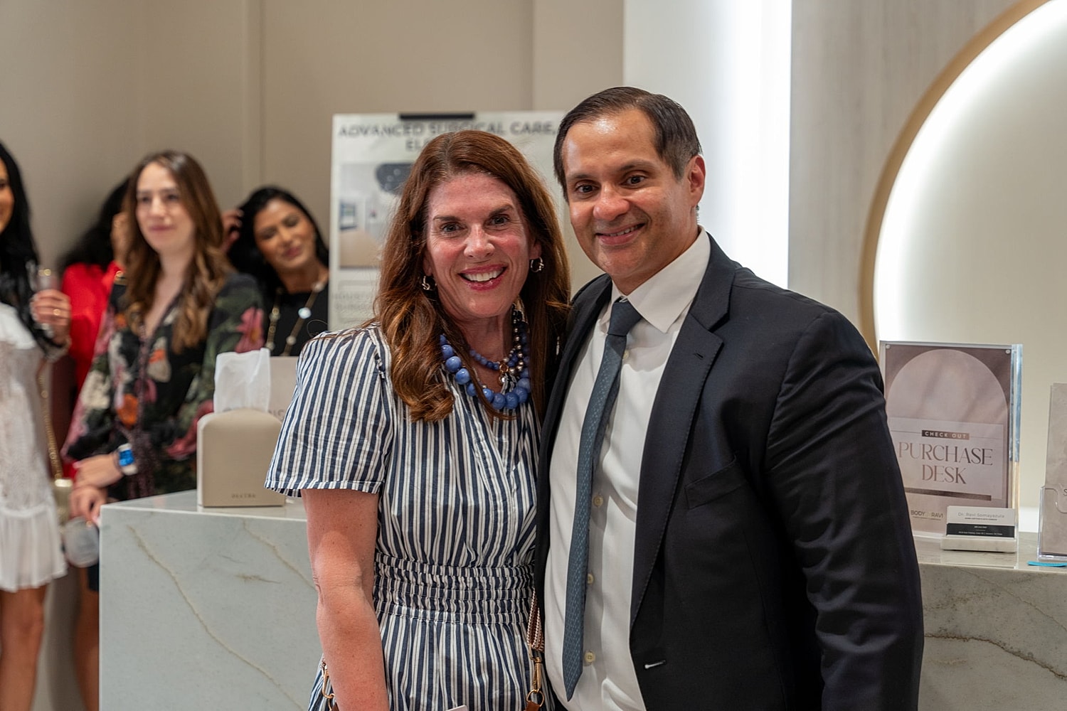 Two people smiling at an event.