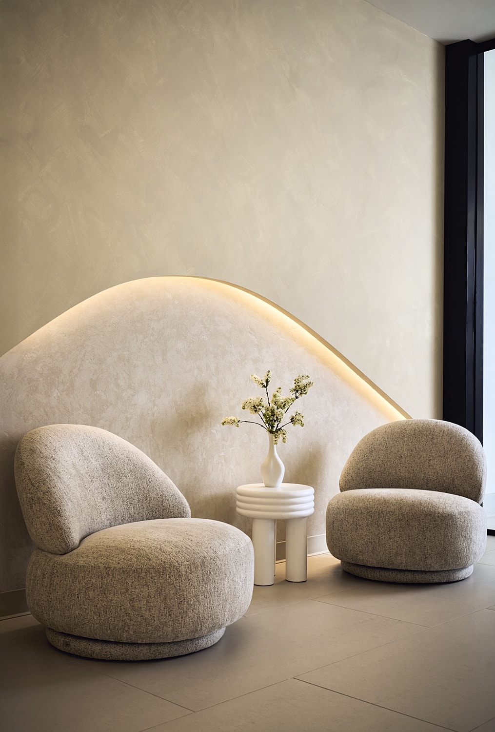 Modern chairs with decorative vase and minimalistic design.