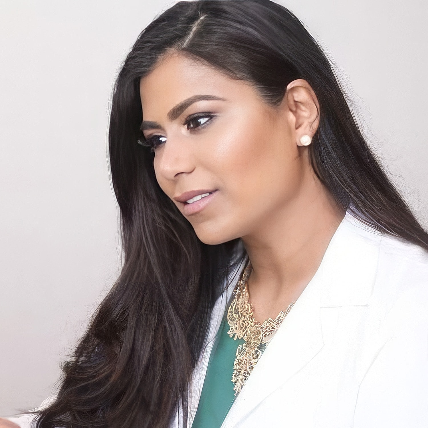 Professional woman in white coat, thoughtful expression.