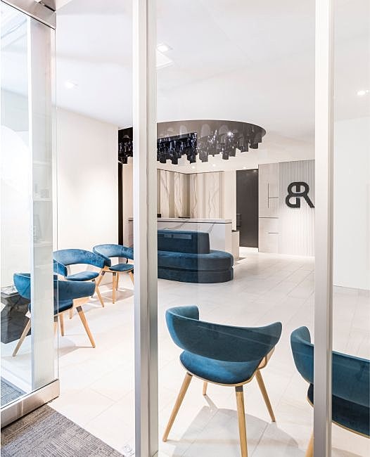 Body by Ravi Modern reception area with stylish blue chairs.