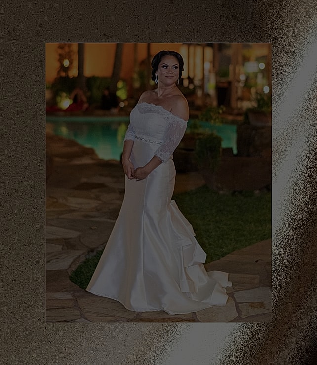 Bride in elegant wedding dress by a pool.
