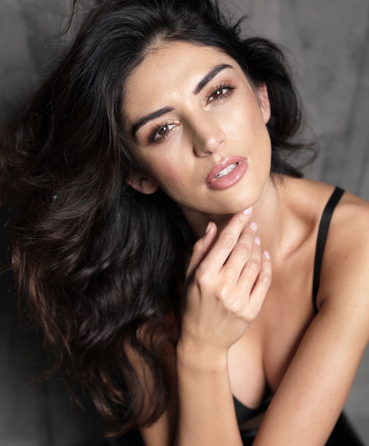 Woman with long hair posing thoughtfully.