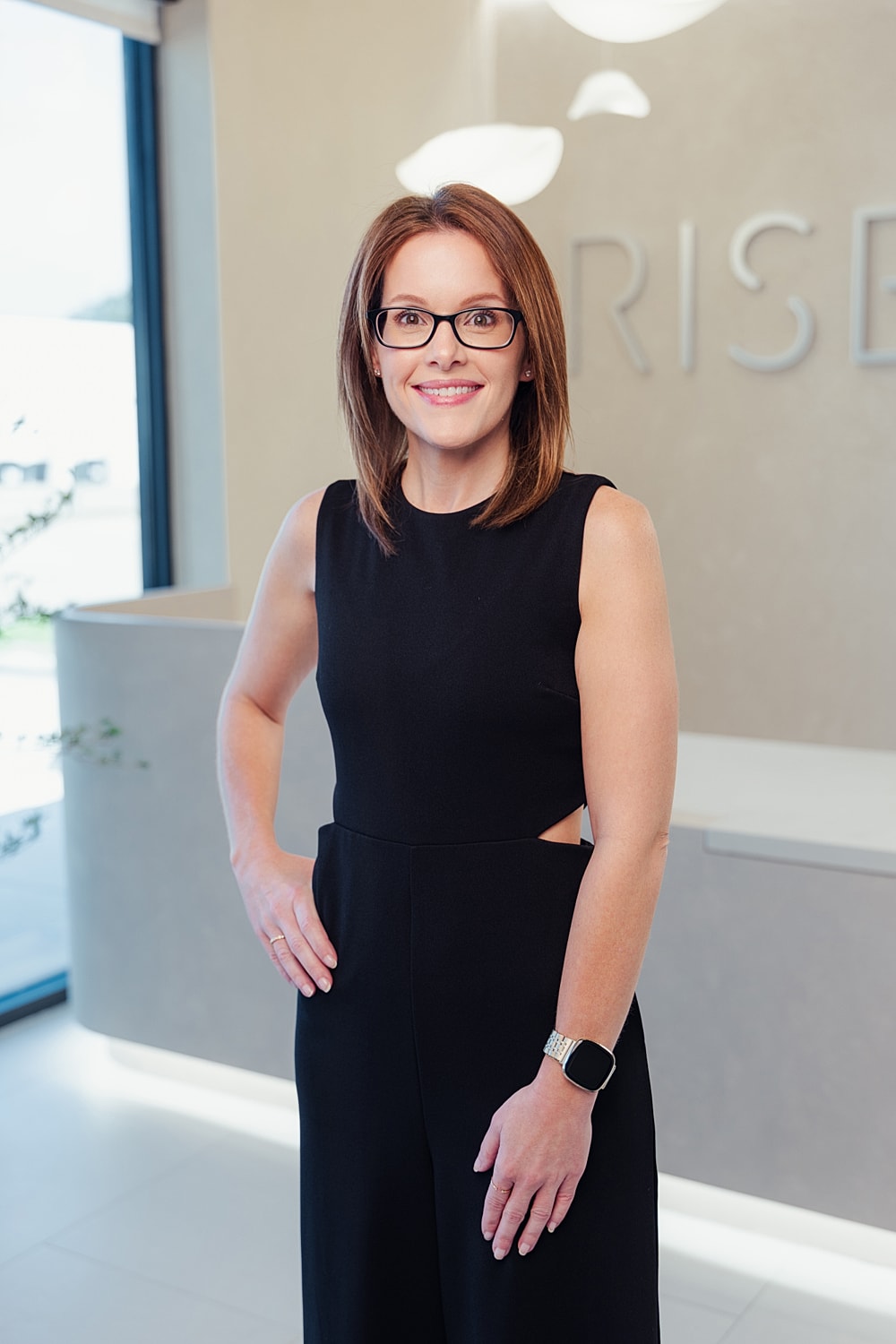Professional woman smiling in modern office setting.