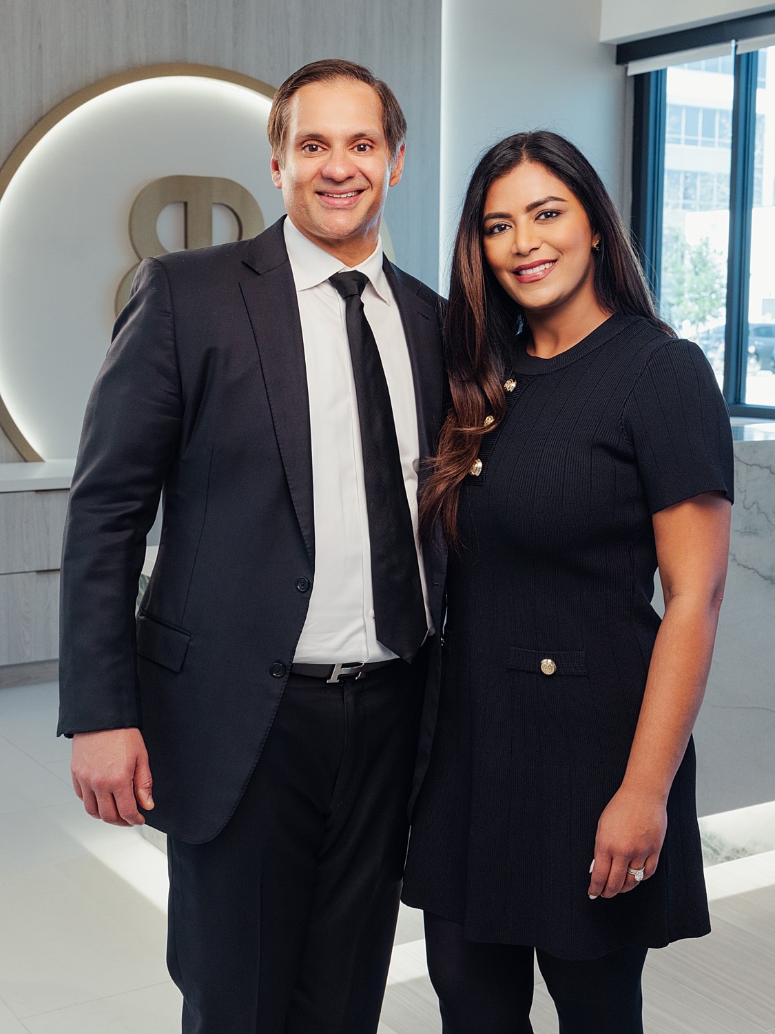 Professional portrait of two smiling individuals.