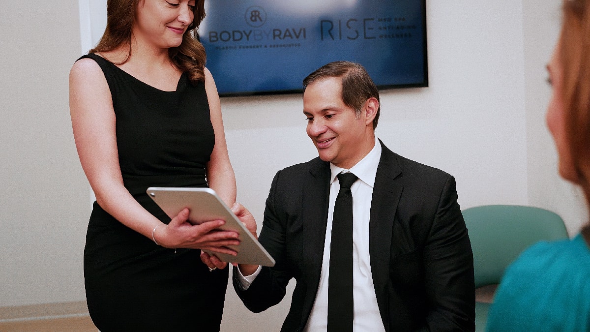 Consultation in healthcare setting with tablet discussion.