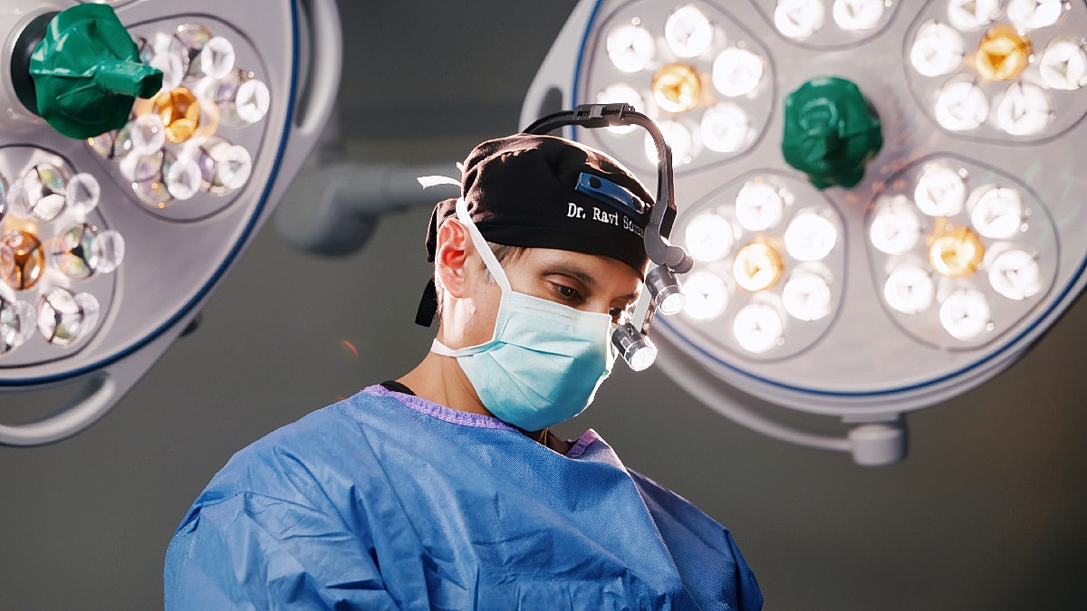 Surgeon preparing for operation under bright lights.