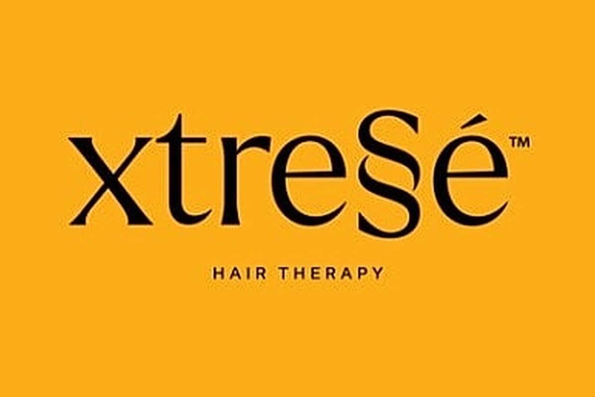 xtrese Hair Therapy logo on orange background