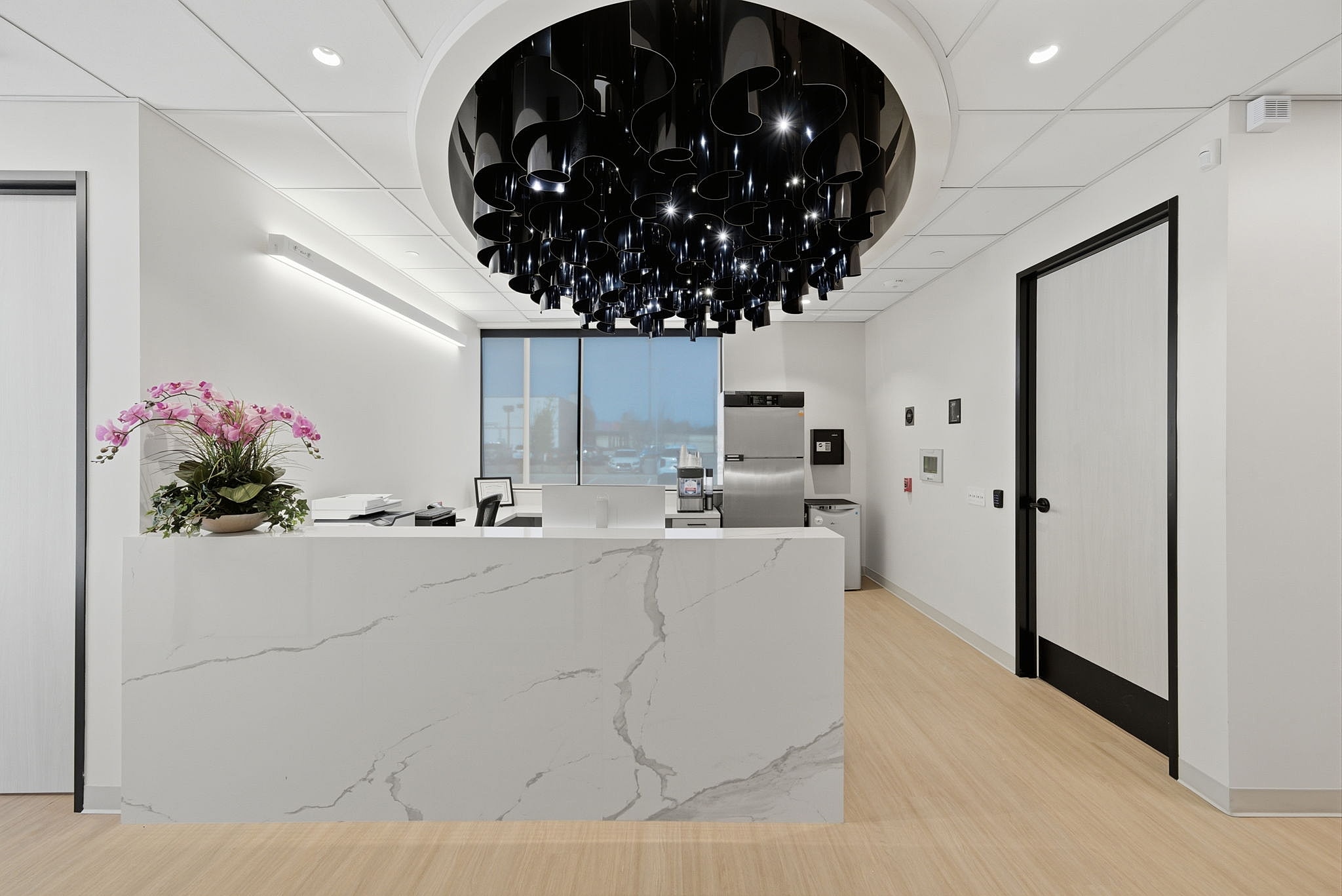 Modern treatment room with black chairs and decor.