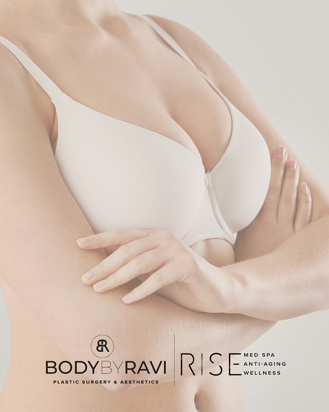 Model wearing a white bra, arms crossed.